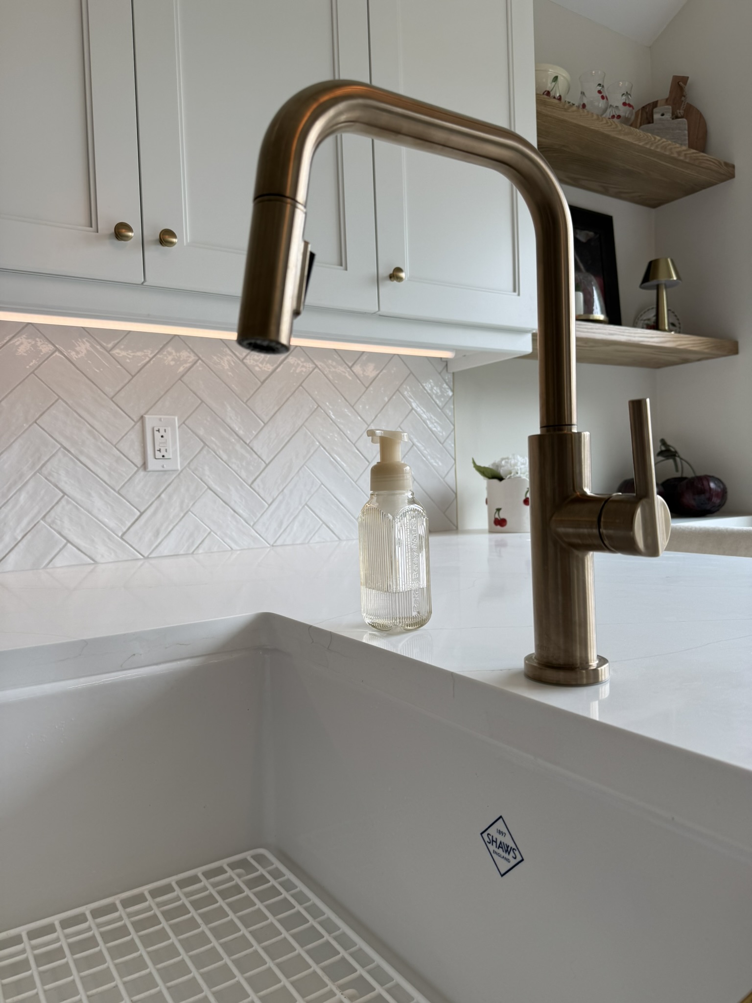 Sink, brass faucet and herringbone backsplash detail