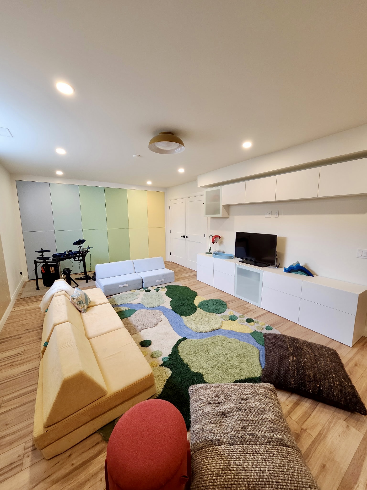 Recreation room with a colourful custom-painted storage wall