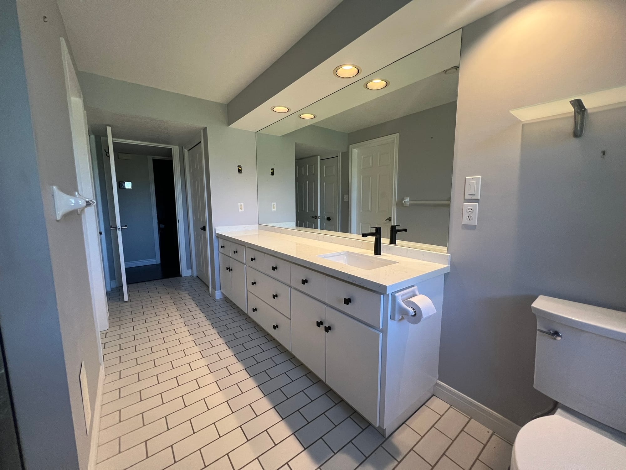 Completed bathroom with long vanity and integrated mirror lighting